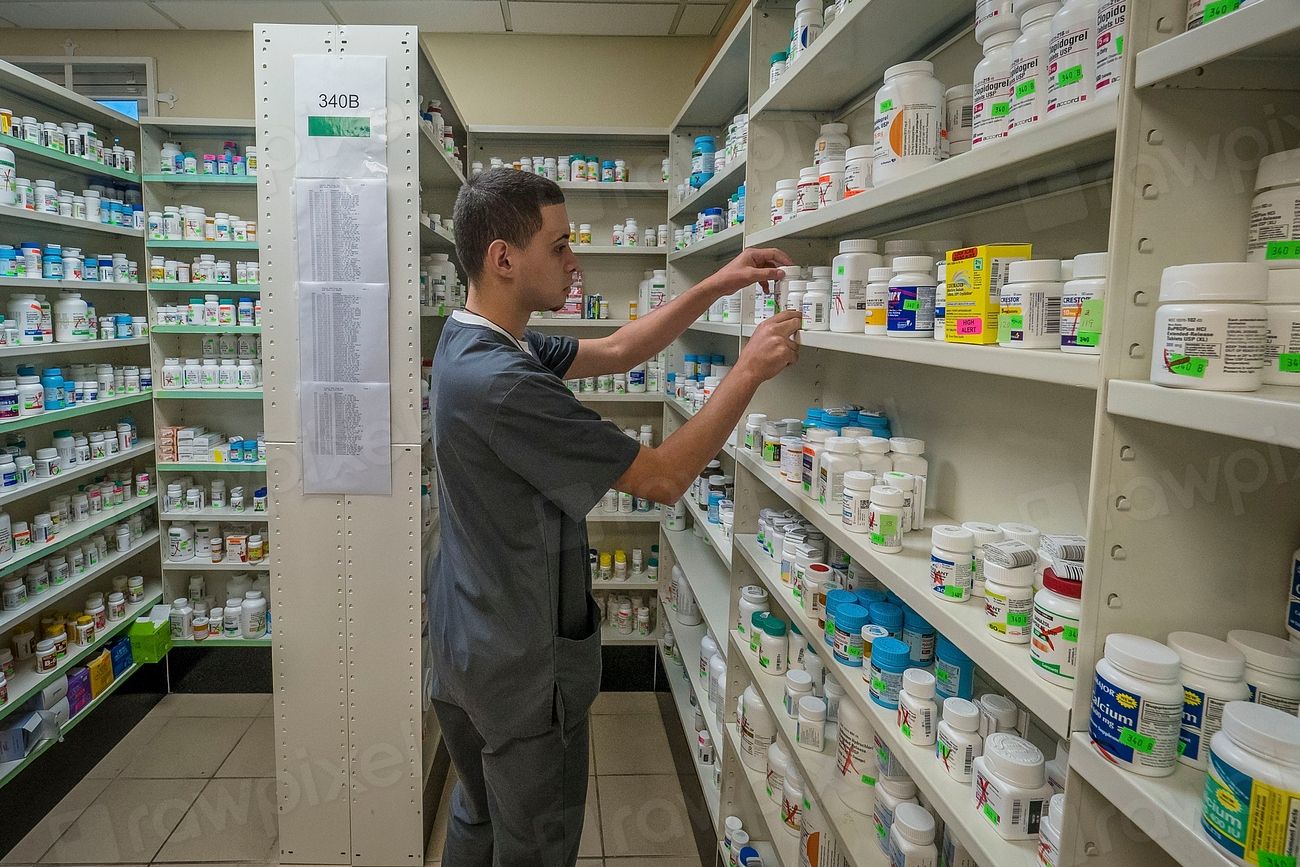 Pharmacien rangeant des médicaments en rayon